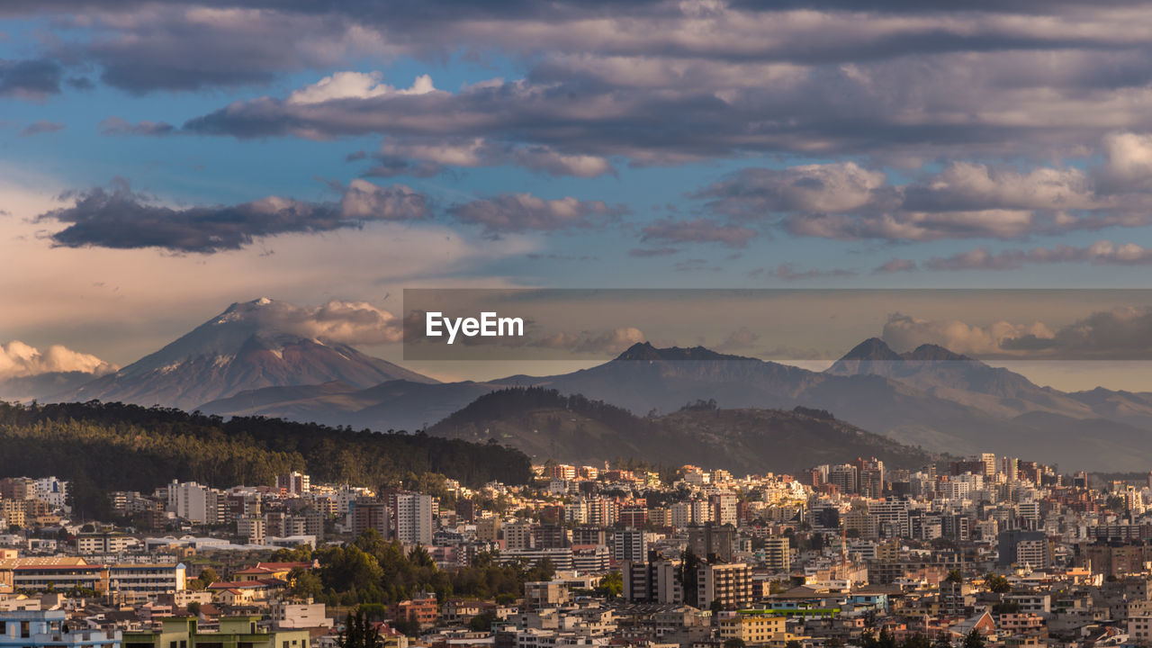 Aerial view of city against cloudy sky