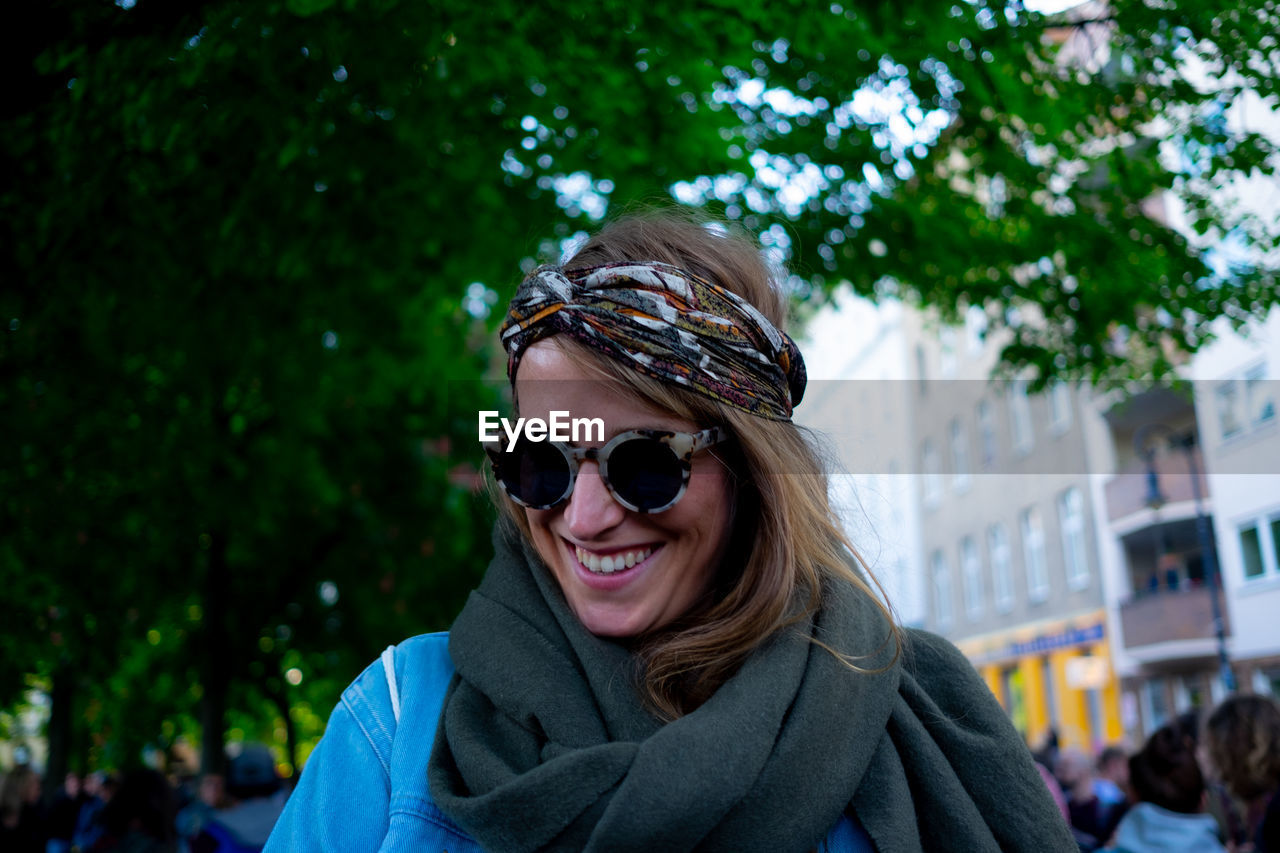 PORTRAIT OF SMILING WOMAN WEARING SUNGLASSES