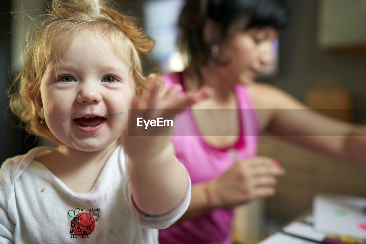 Happy smilling cute little girl pointing thowards the camera