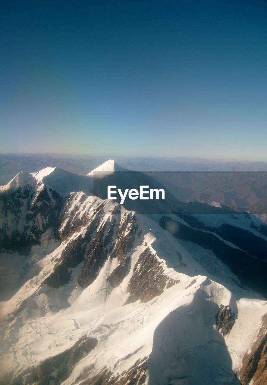 Scenic view of snowcapped mountains against clear sky