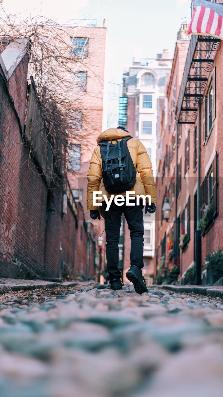 MAN STANDING ON COBBLESTONE