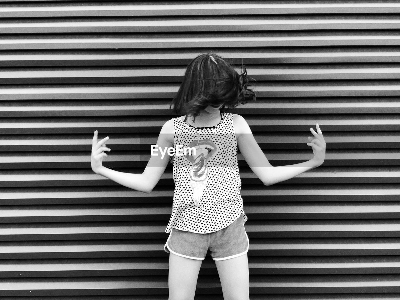 Girl standing against corrugated iron