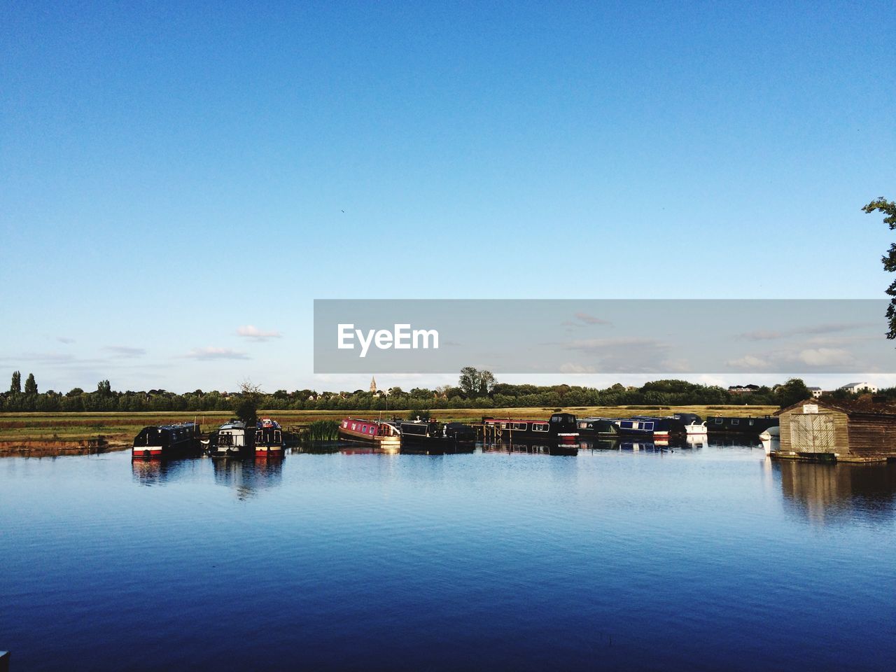 Scenic view of boats moored on lake against sky