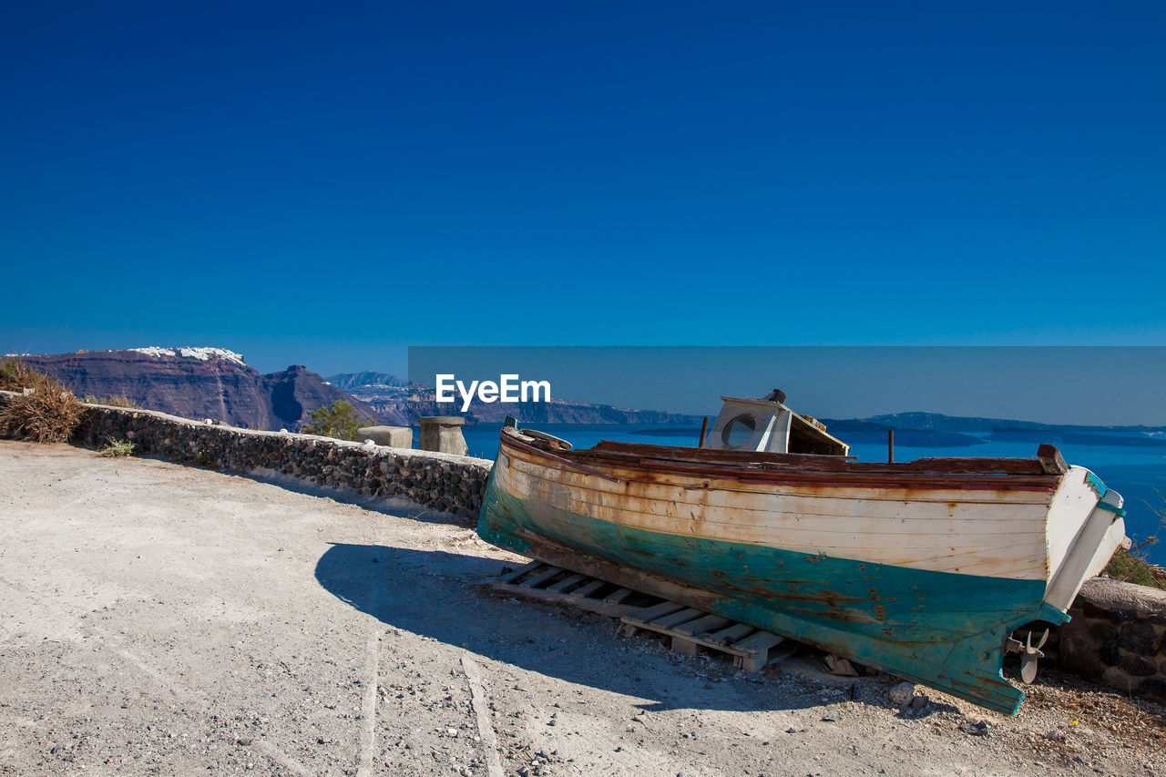 Old boat on the top of a cliff in santorini island in a beautiful early spring day