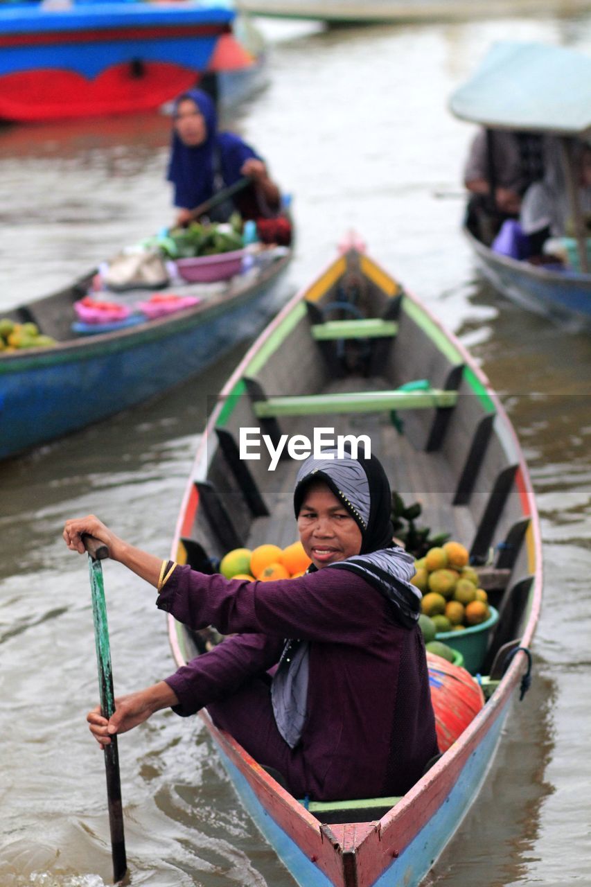 Woman selling food on boat in lake