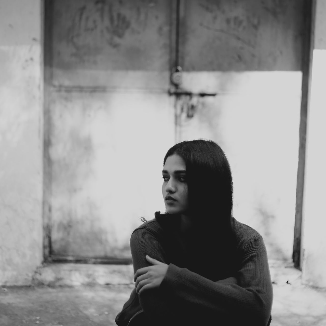 Serious young woman looking away while sitting outdoors