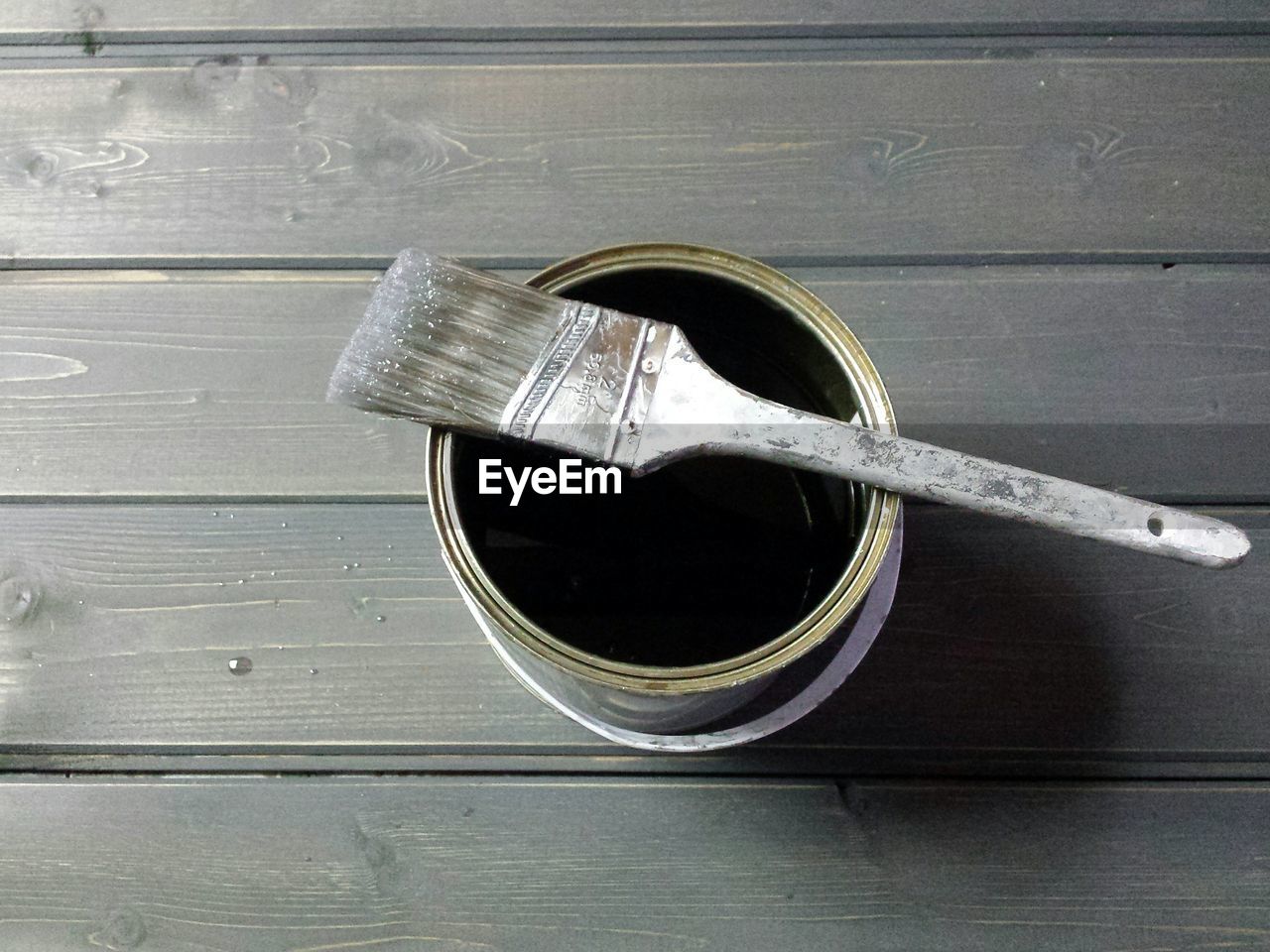 High angle view of paint can on wooden table