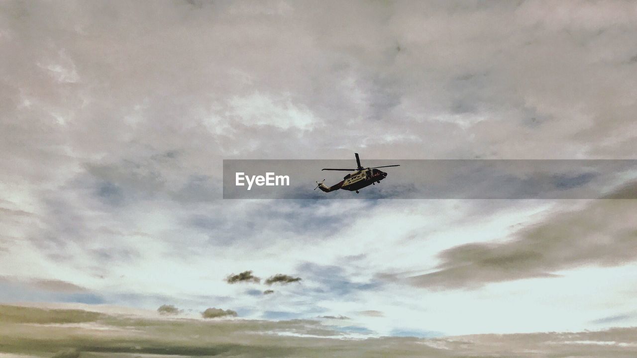 LOW ANGLE VIEW OF AIRPLANE IN FLIGHT AGAINST SKY