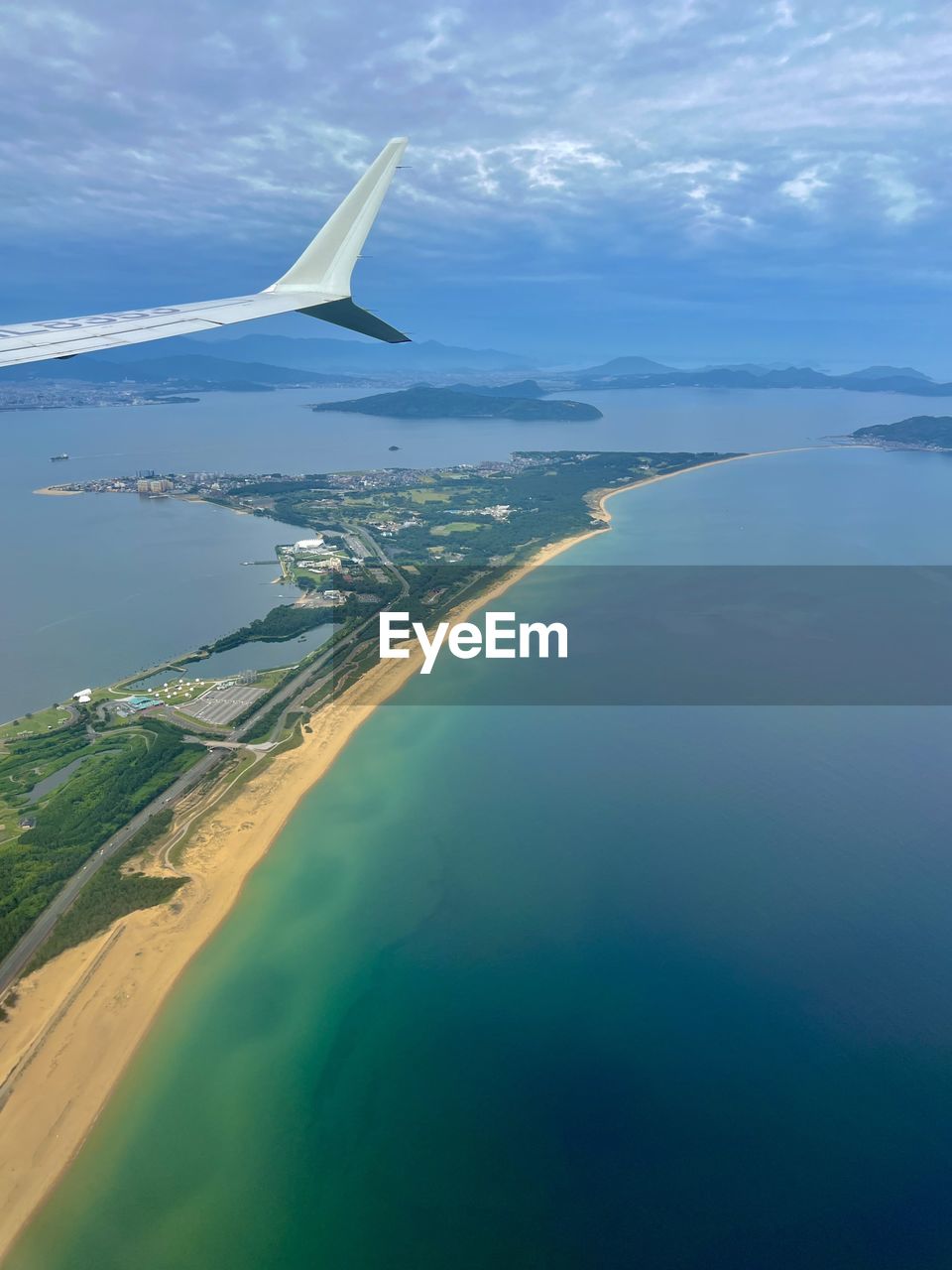 water, aerial view, sea, airplane, flying, transportation, travel, air vehicle, aircraft wing, nature, horizon, sky, land, mode of transportation, environment, beach, blue, travel destinations, cloud, scenics - nature, no people, coast, aerial photography, beauty in nature, day, landscape, ocean, coastline, outdoors, mid-air, motion, trip, tourism, vacation, journey, holiday, island, tranquility, bay, tranquil scene