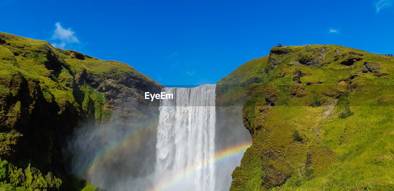 Scenic view of waterfall against sky