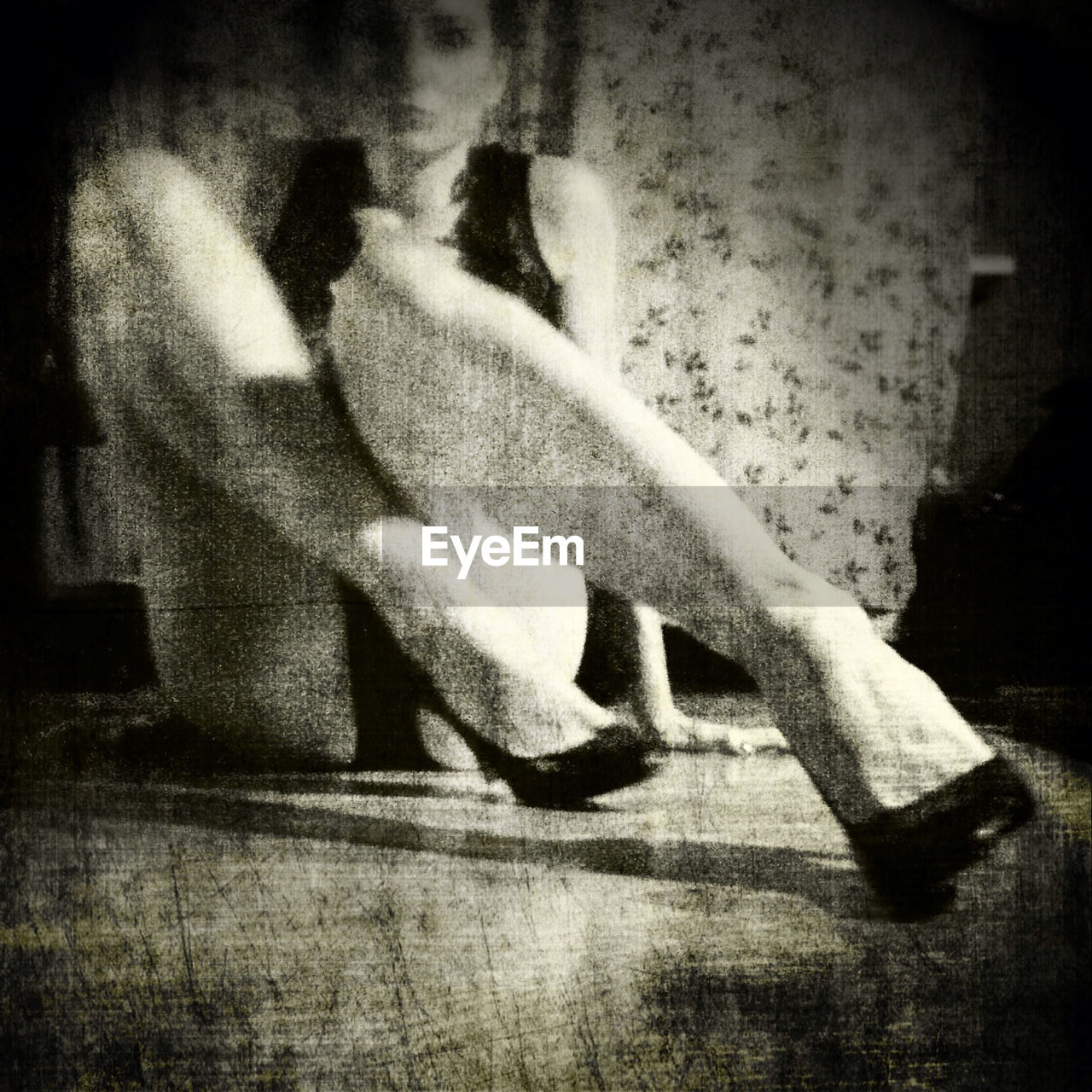 Woman in high heels sitting on floor