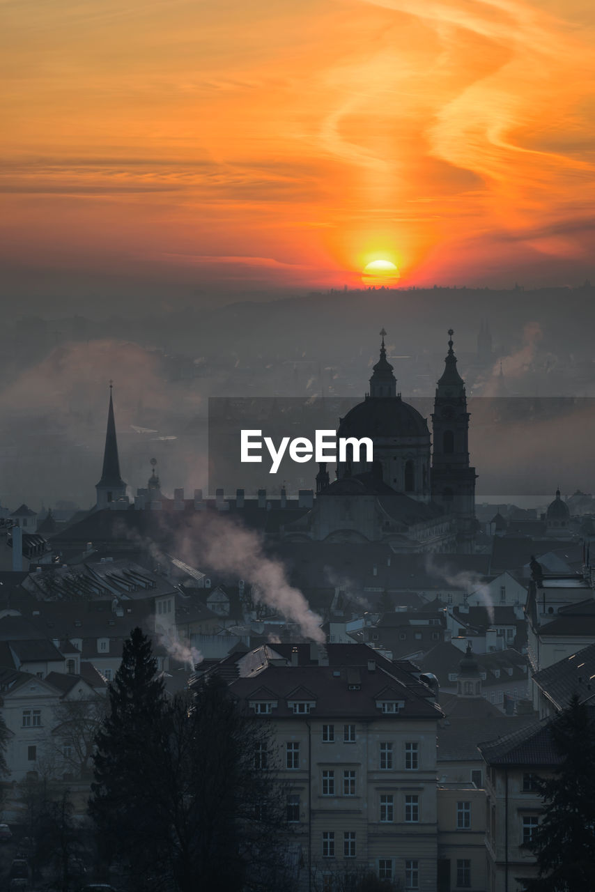 High angle view of silhouette buildings against sky during sunset