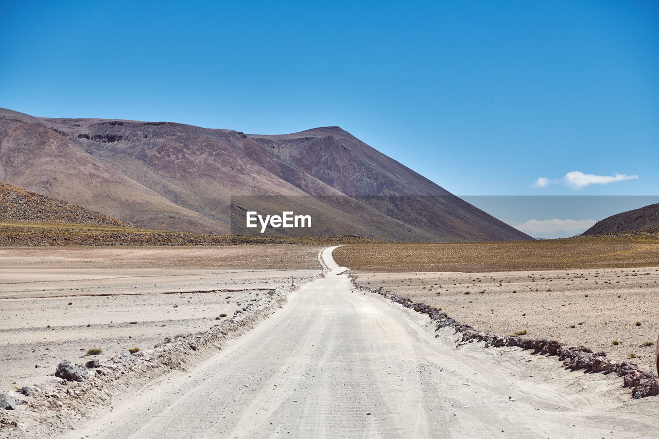 Scenic view of road amidst desert against sky