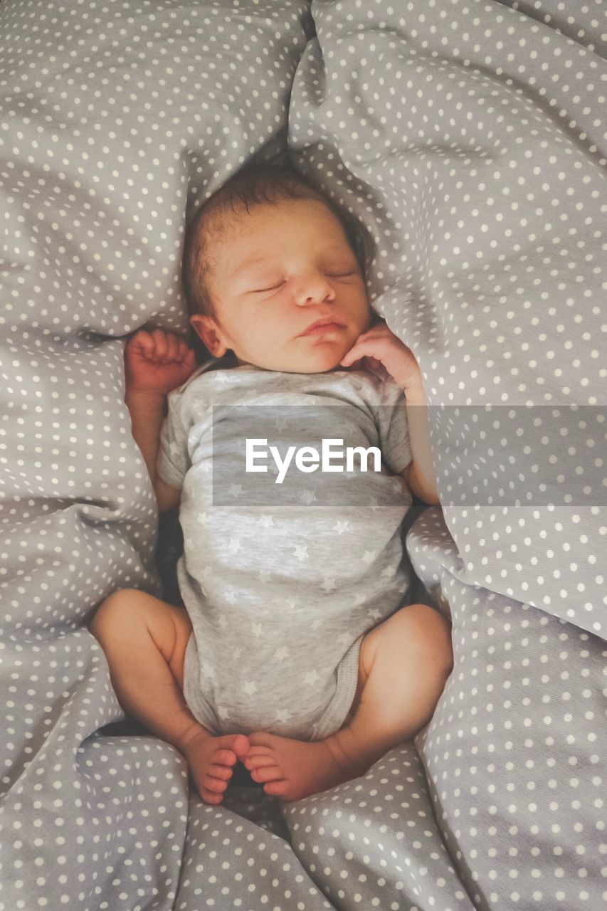 Directly above shot of baby boy sleeping on bed