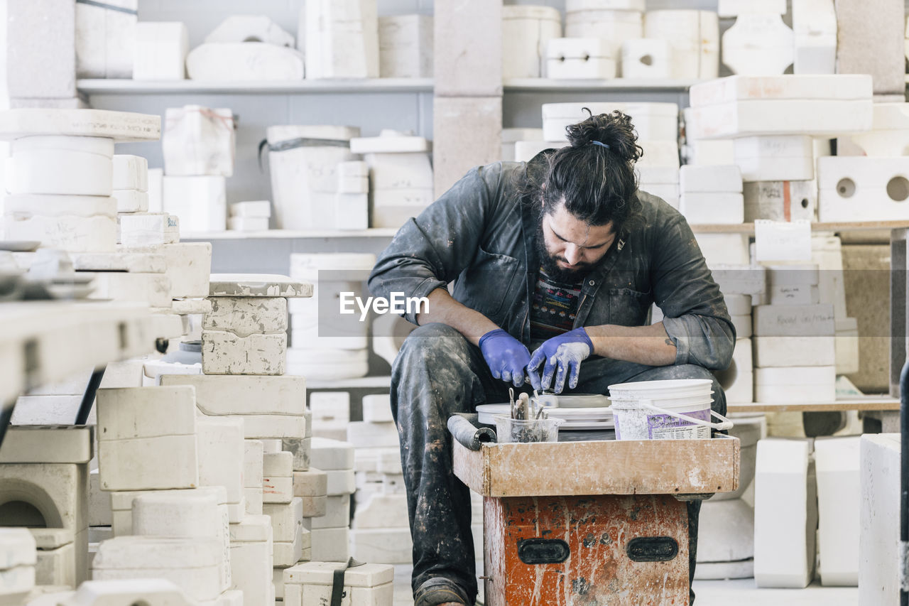 Craftsman using pottery wheel while working in art studio