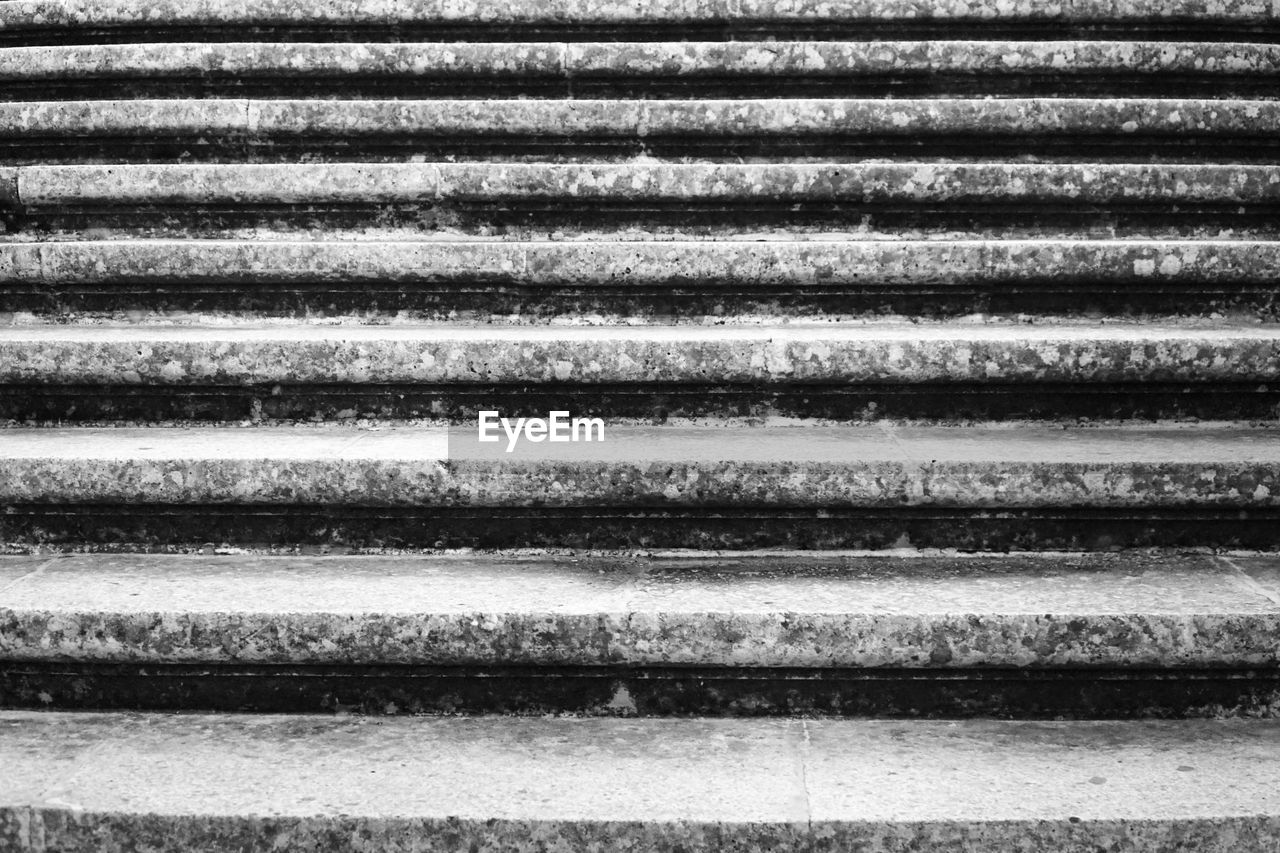 Old, hard, stone / rock / concrete stairs in castle - black and white texture backgound