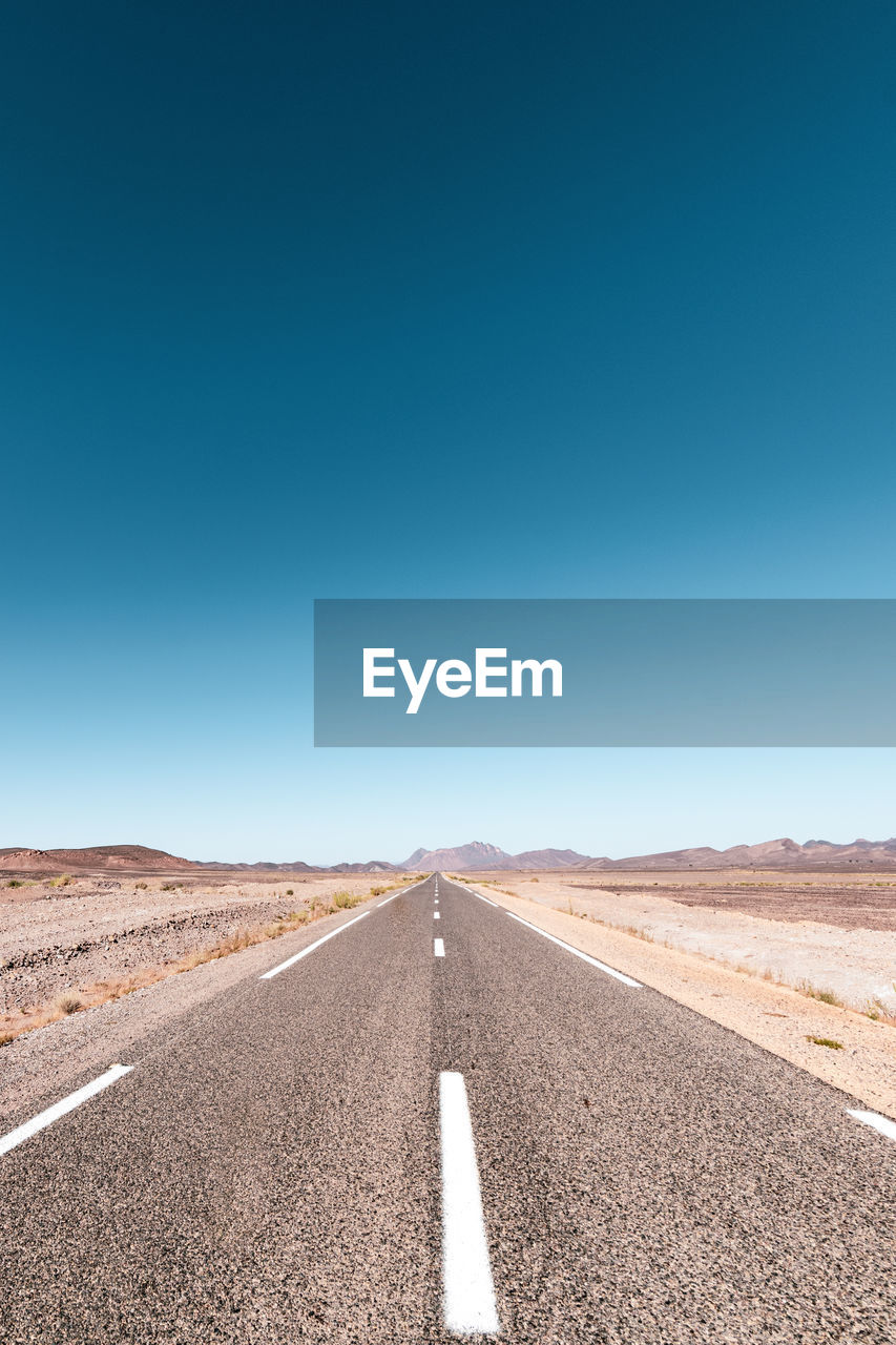 Scenic view of road against clear blue sky