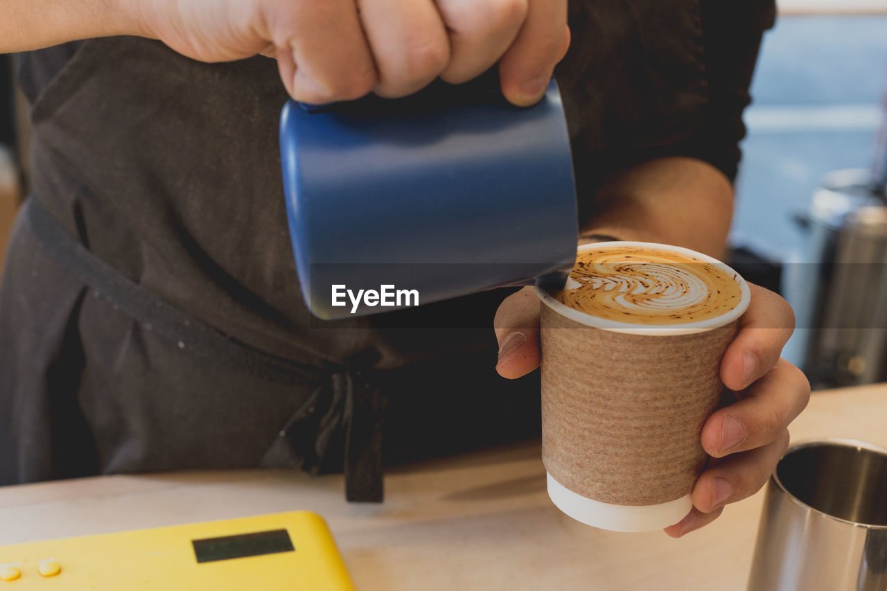 Midsection of woman holding coffee cup