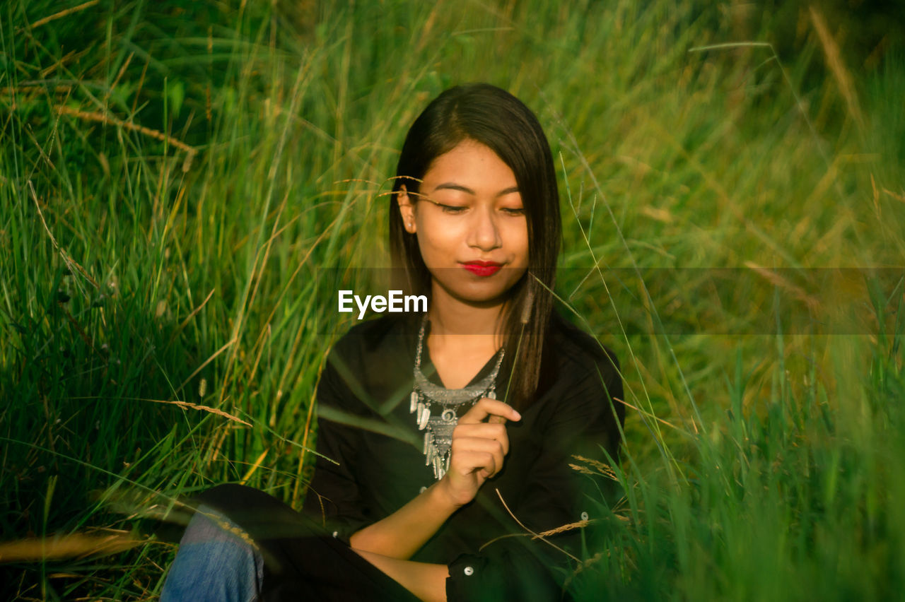 Young woman sitting amidst grass