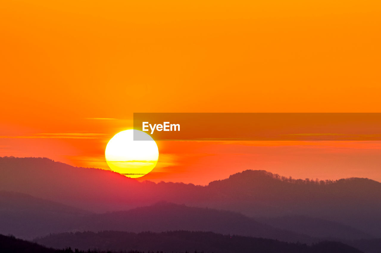 SCENIC VIEW OF SILHOUETTE MOUNTAINS AGAINST ROMANTIC SKY