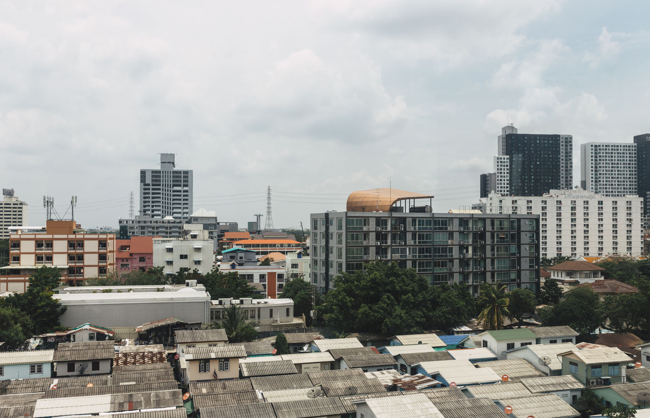 High angle view of city buildings against cloudy sky