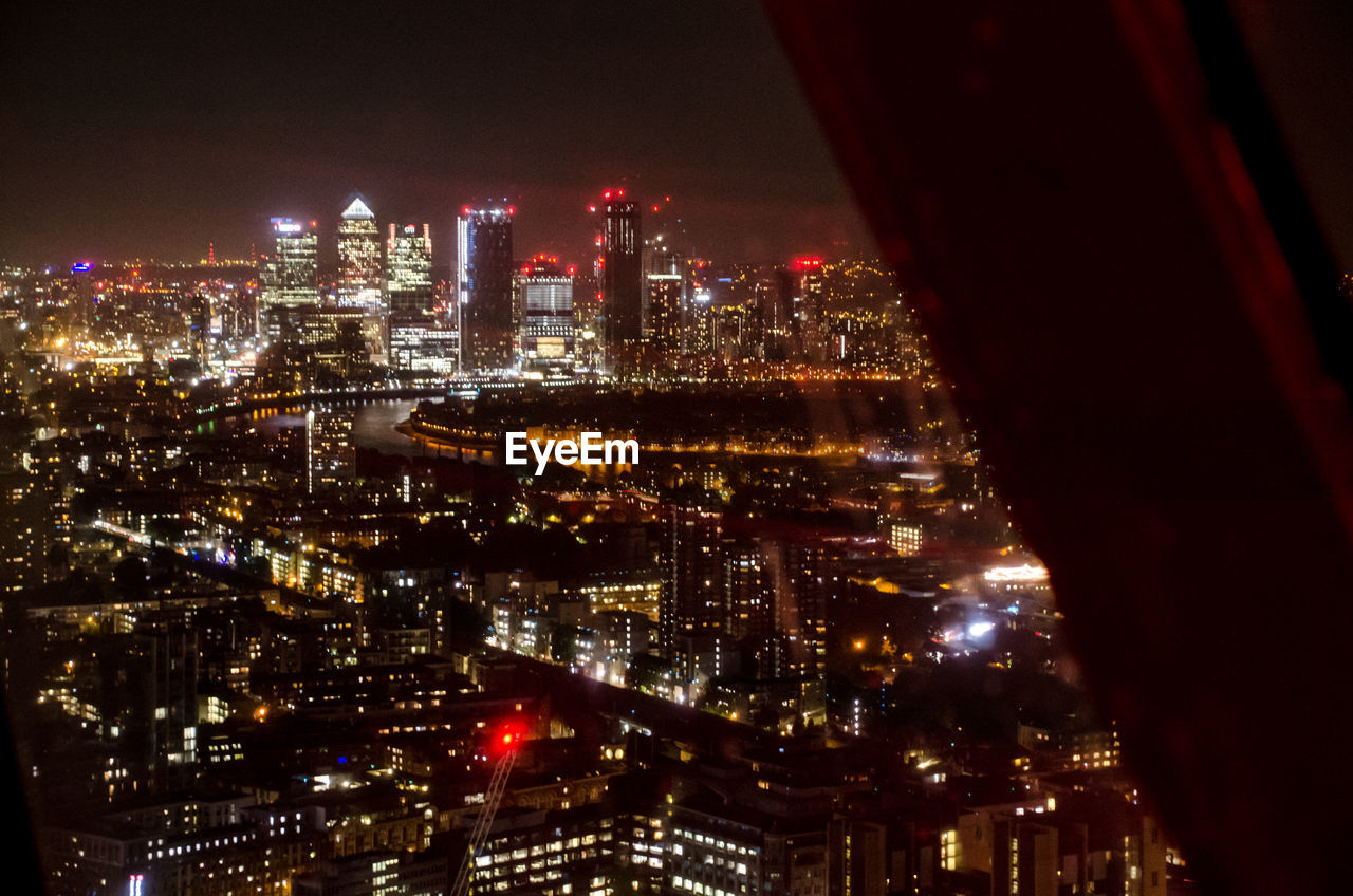 HIGH ANGLE VIEW OF ILLUMINATED CITY BUILDINGS AT NIGHT