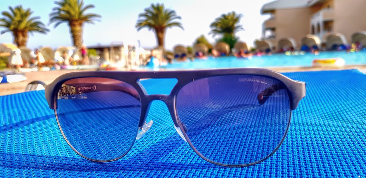REFLECTION OF SUNGLASSES ON SWIMMING POOL