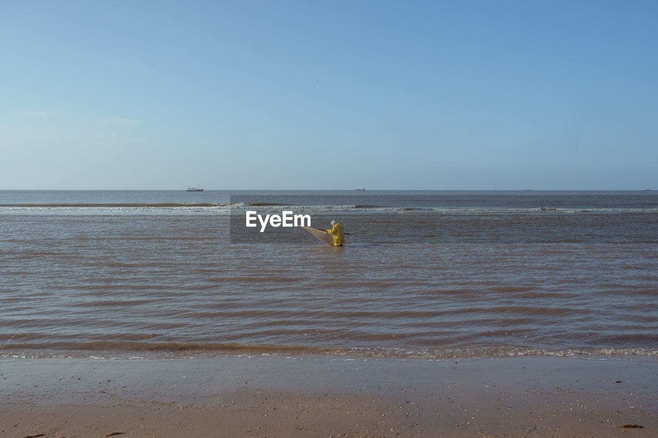 People on beach against sky