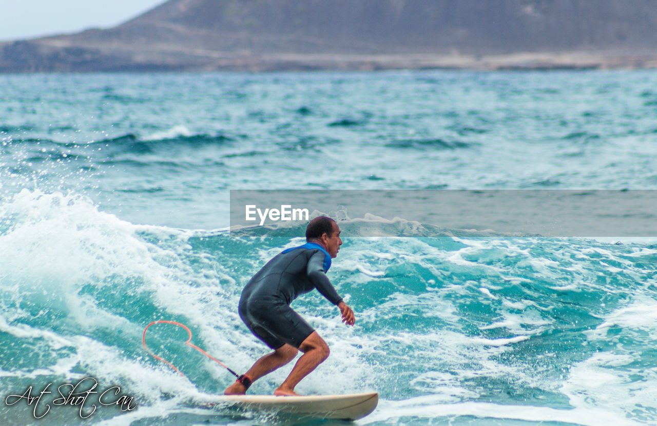 MAN SURFING ON SEA