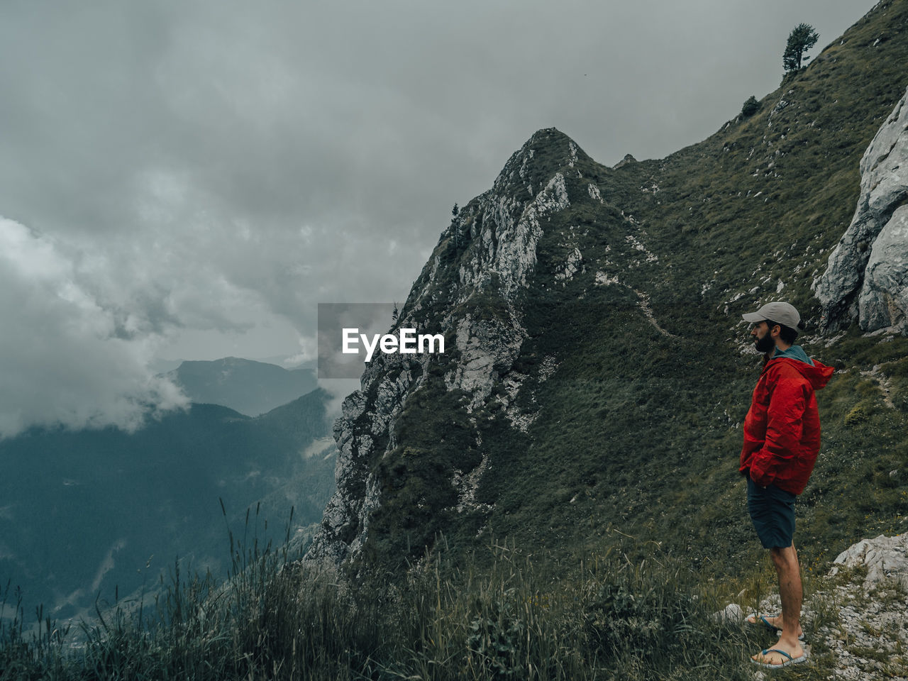 Rear view of man standing on mountain against sky