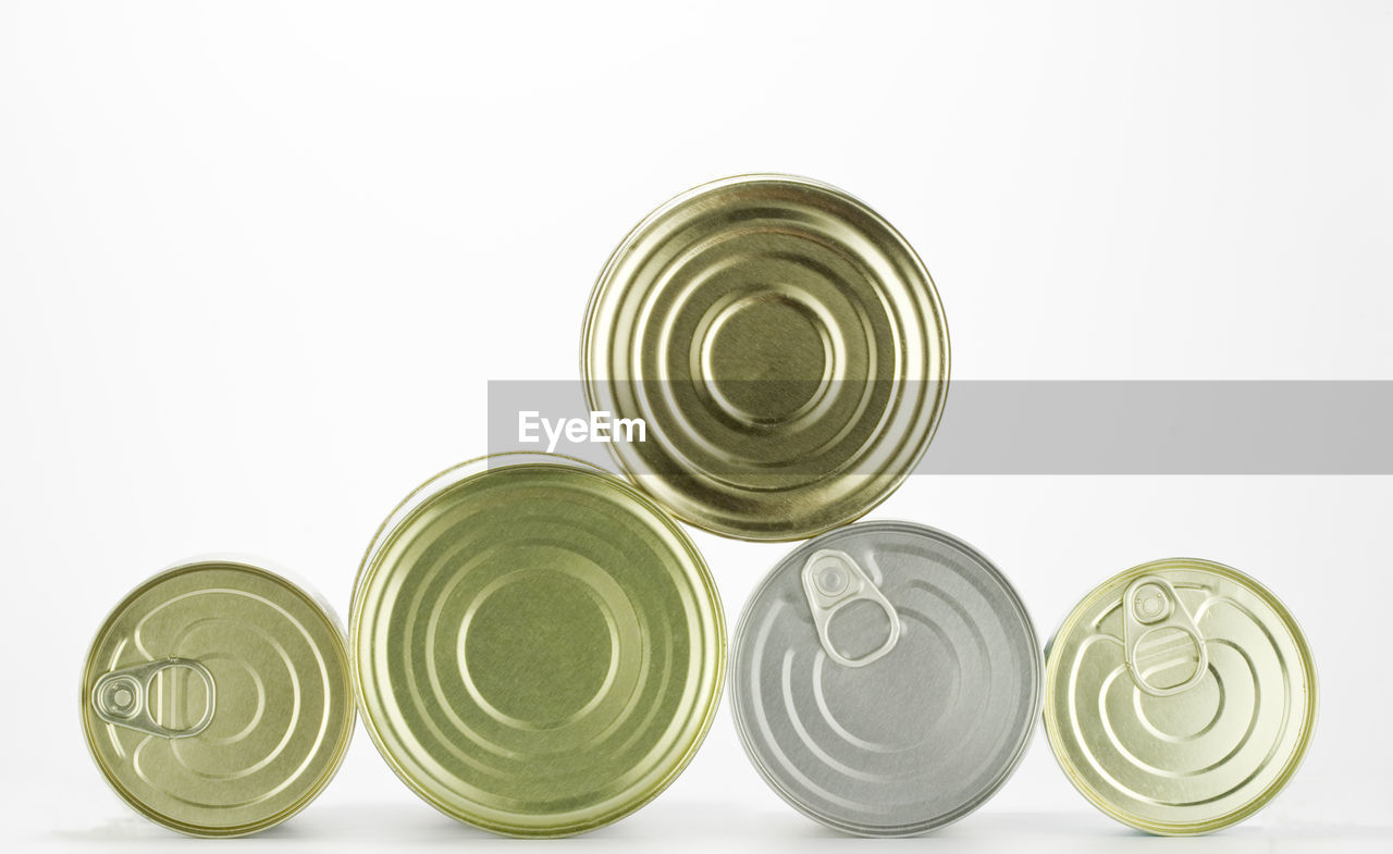 Close-up of tin cans over white background