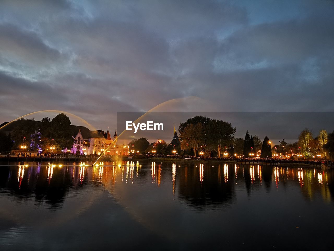 Lake in illuminated city at night