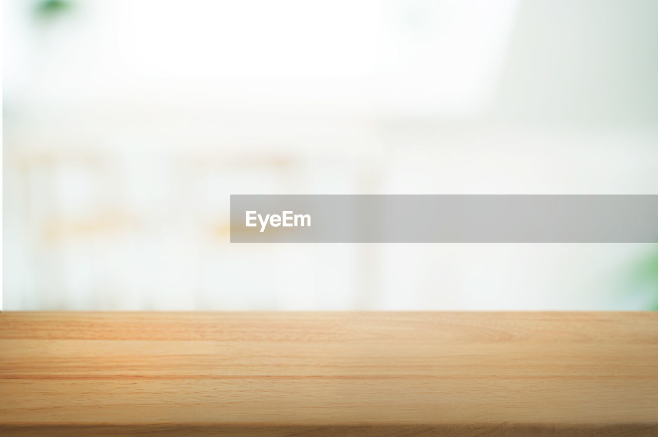 CLOSE-UP OF WOODEN TABLE AGAINST WALL