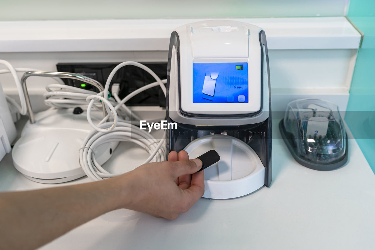 Hand of nurse scanning x-ray in modern machine at clinic