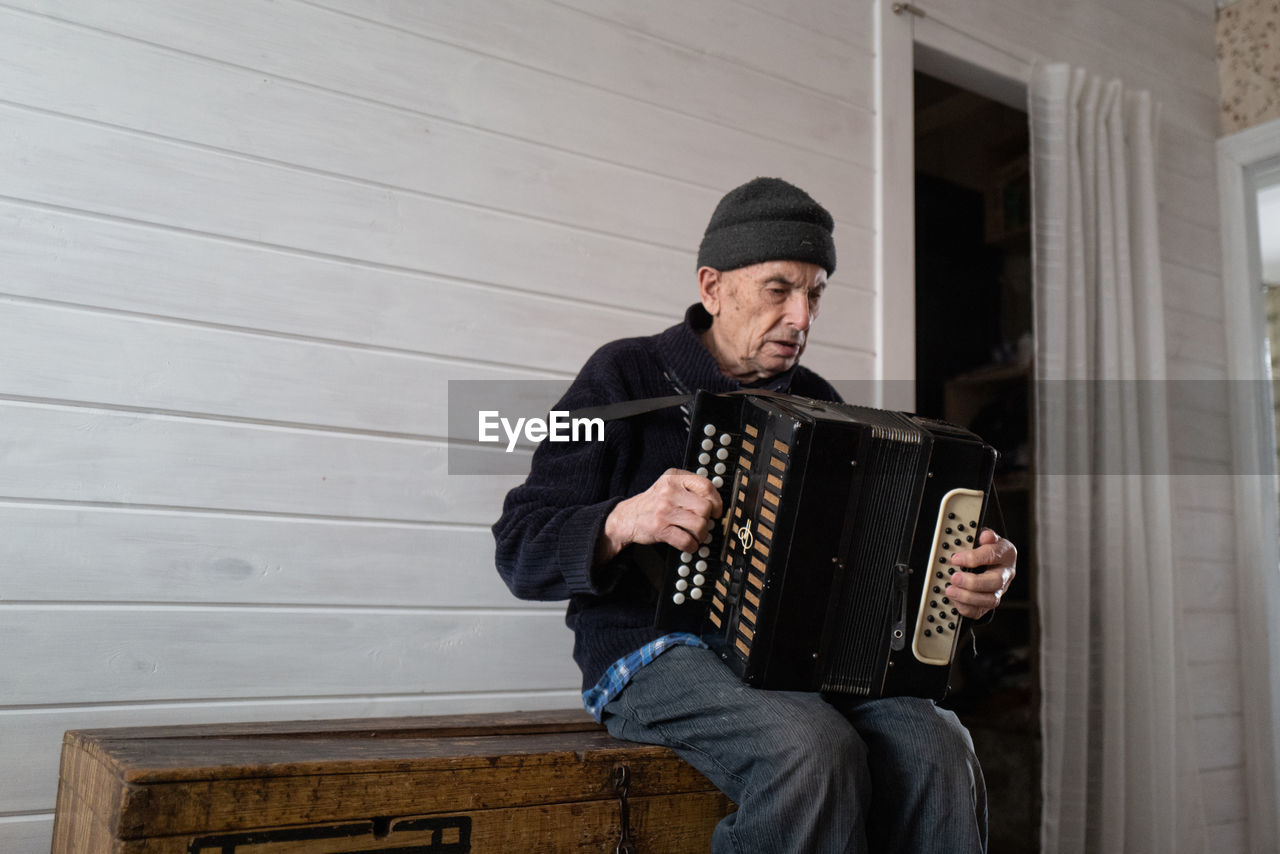 Old man playing harmonica