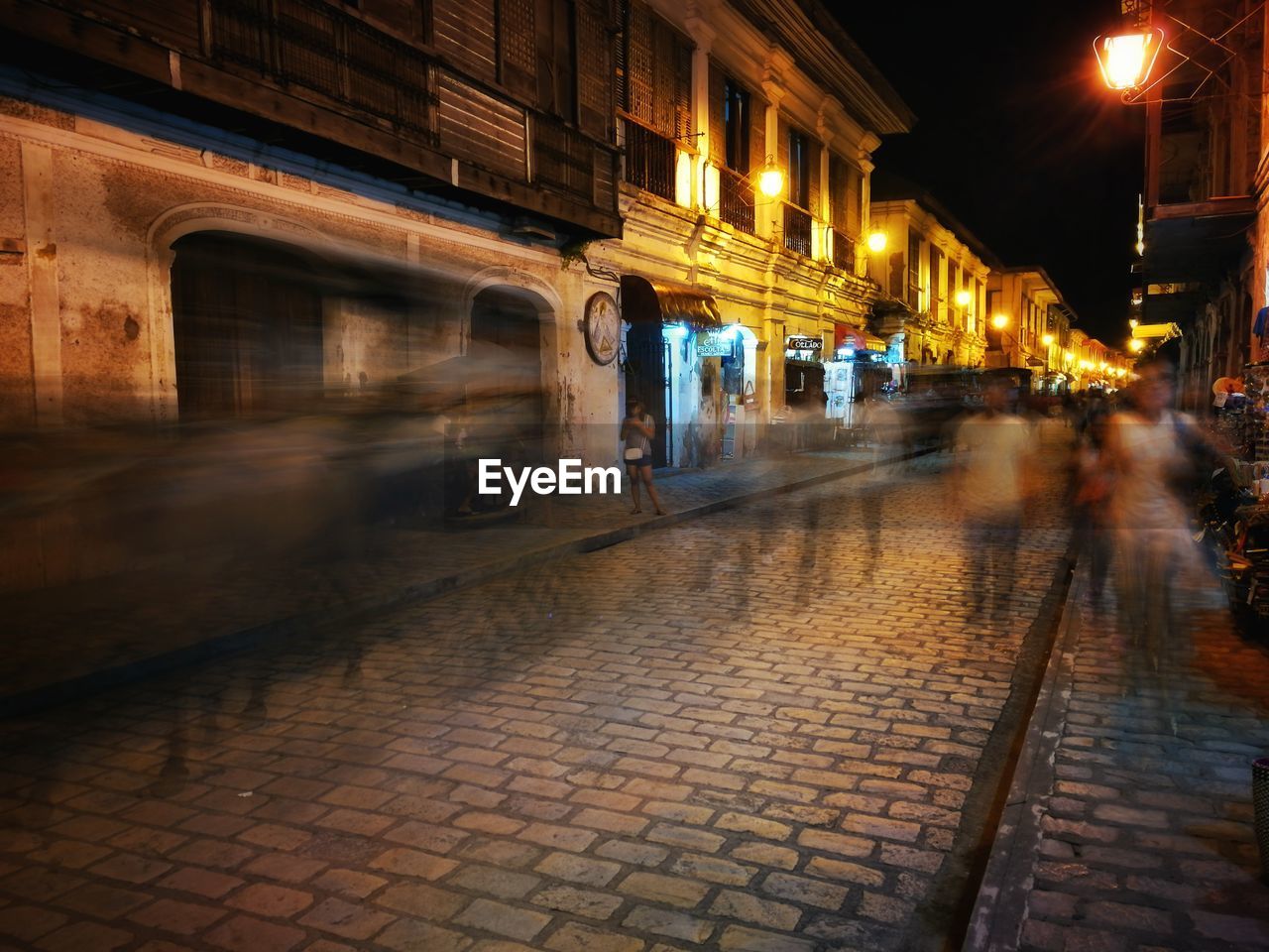 People walking on sidewalk at night