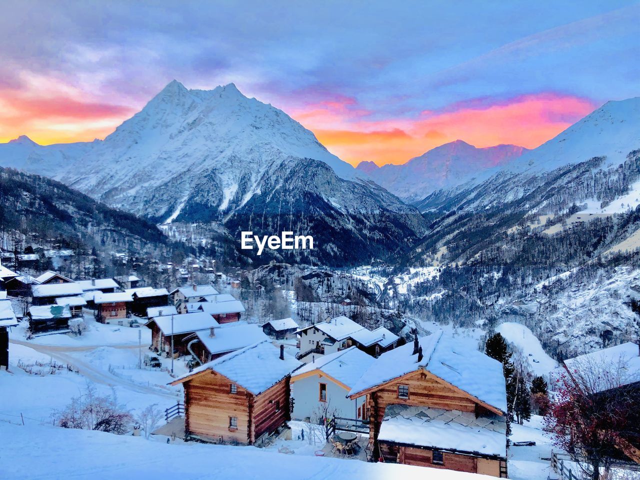 Houses on snow covered mountain against sky