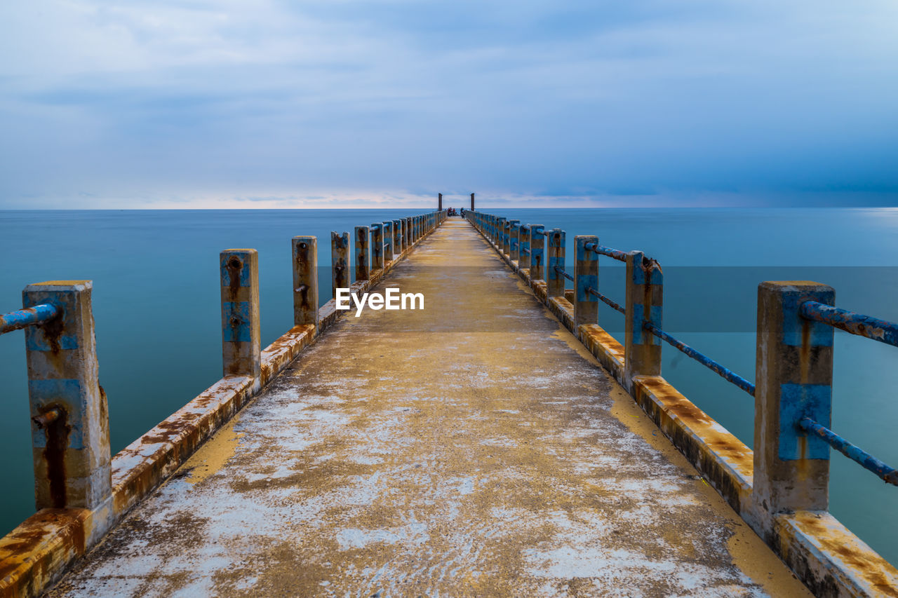 Wooden pier on sea against sky