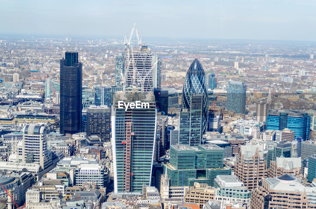 Aerial view of buildings in city against sky