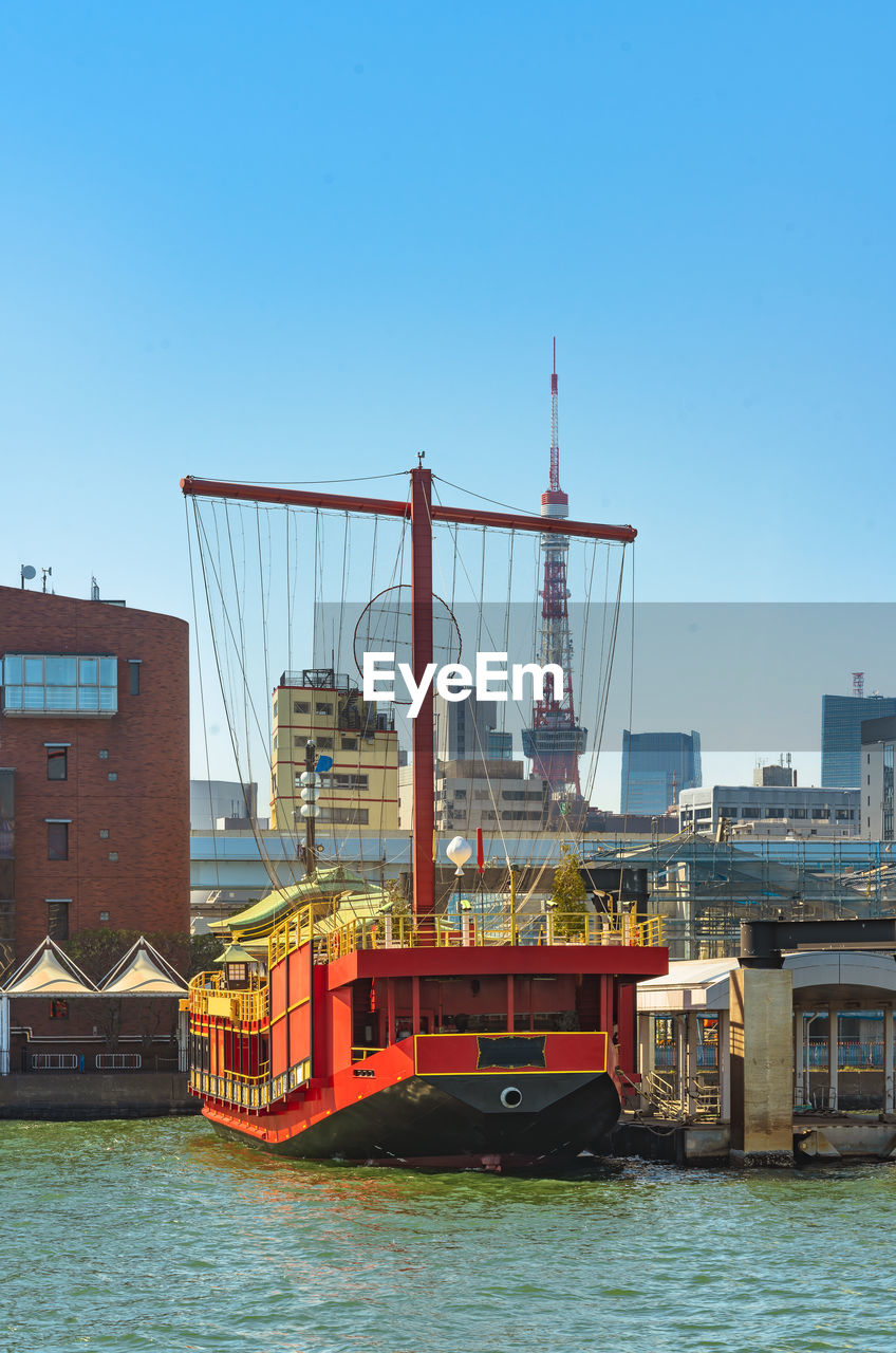 VIEW OF SAILBOAT IN CITY AGAINST CLEAR SKY