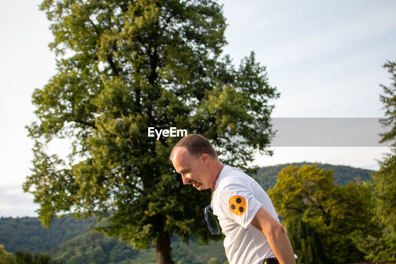 Low angle view of man standing against trees