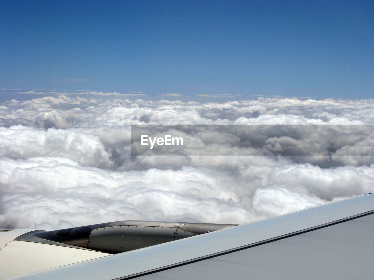 AERIAL VIEW OF CLOUDSCAPE OVER AIRPLANE WING