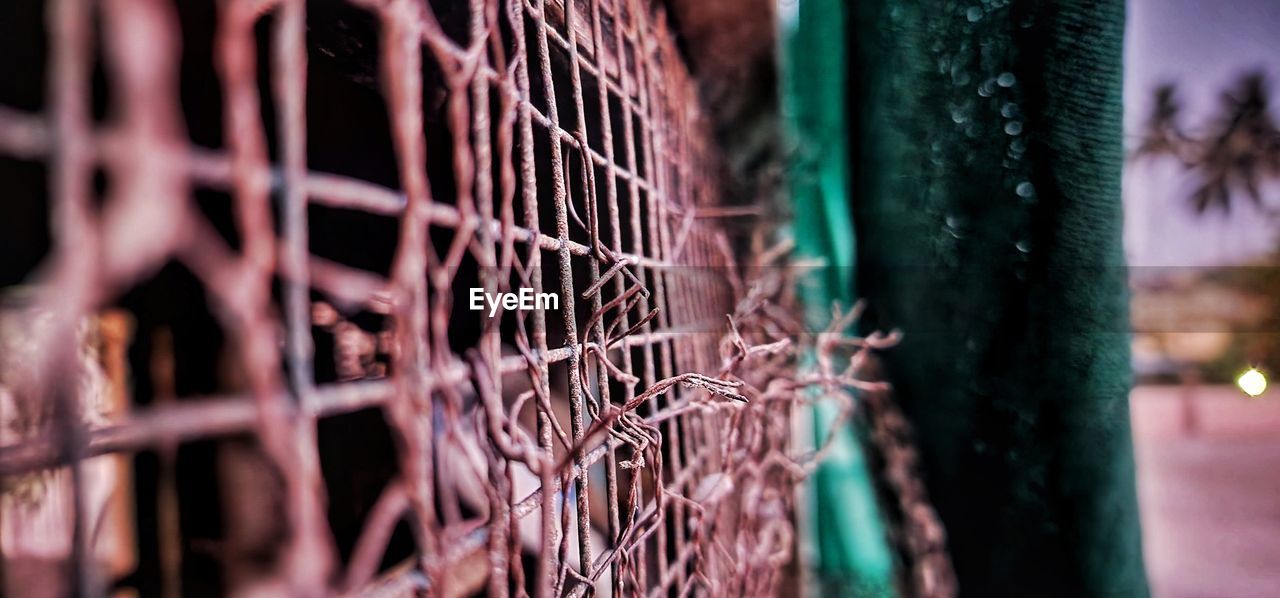 selective focus, no people, fence, sports, close-up, metal, focus on foreground, outdoors, red, day, green, nature, light, security