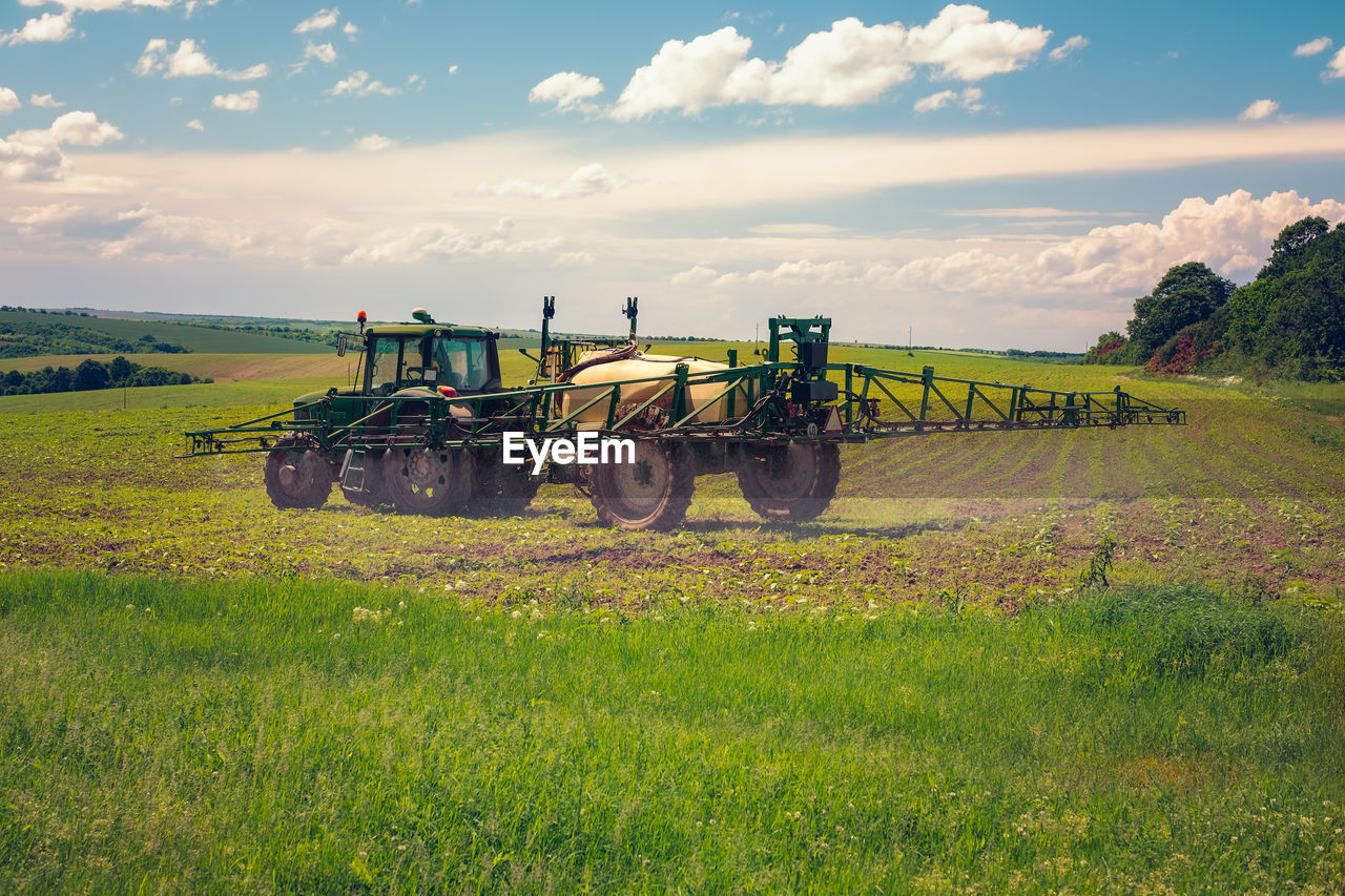 Farm machinery spraying insecticide to the agricultural field