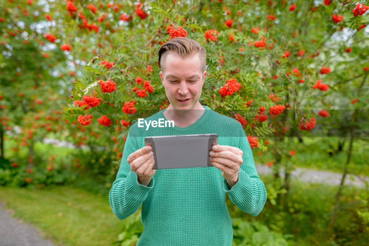 YOUNG WOMAN USING MOBILE PHONE OUTDOORS
