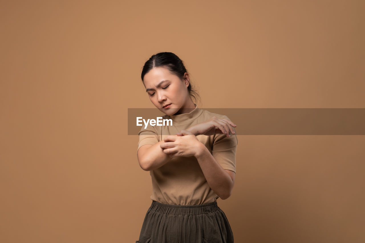 studio shot, one person, colored background, adult, women, indoors, young adult, portrait, copy space, photo shoot, standing, hairstyle, dancing, emotion, female, fashion, brown hair, looking, waist up, clothing, front view, hand, holding, person, long hair
