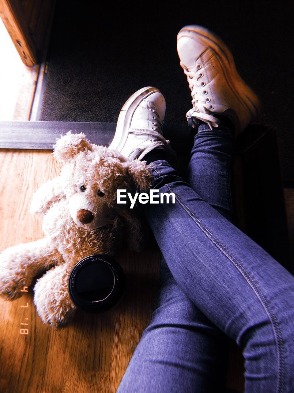 Low section of woman sitting on hardwood floor