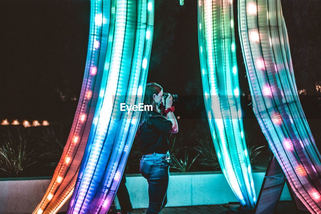 FULL LENGTH OF MAN STANDING ON ILLUMINATED STAGE