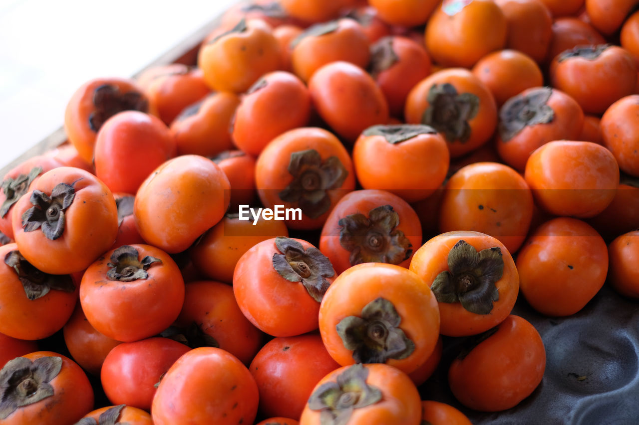 Close-up of persimmons for sale at market stall