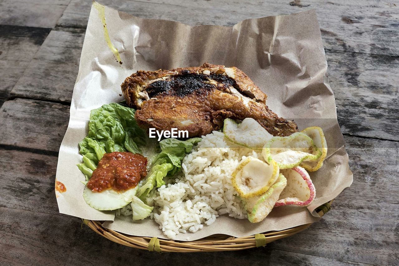 High angle view of ayam penyet served in basket